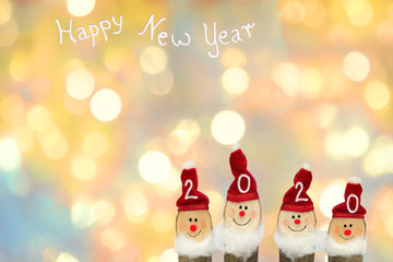 blurry background of christmas lights, four smiling santa clause, Happy new year text and copy space
