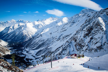 Winter panoramic view of the snowy high mountains of Elbrus and cableway with funicular in the Russia