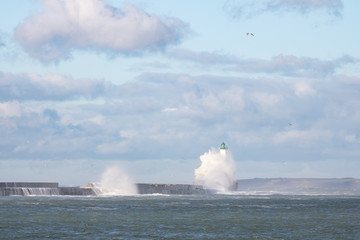 Vague sur la digue Carnot et le phare à Boulogne-sur-Mer (Pas-de-Calais)