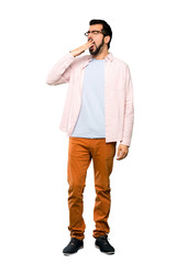 Fototapeta premium Full-length shot of Handsome man with beard yawning and covering wide open mouth with hand over isolated white background