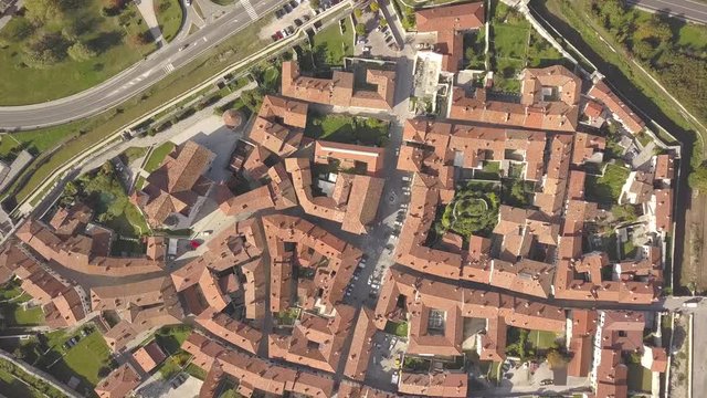 Top down aerial view of a small historic town Venzone in Northern Italy with red tiled roofs of old buildings.