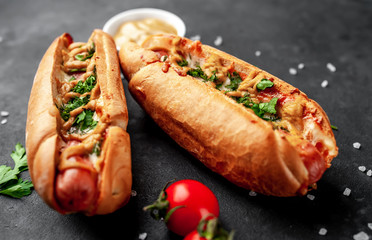 french hot dogs baked with cheese and mustard on a stone background