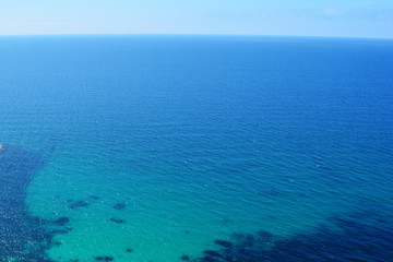 Texture of sea shore with clear turquoise water and sandy bottom. Sea surface aerial top view. Summer beautiful Background.