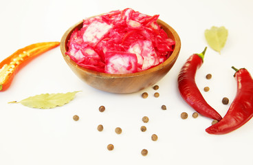 Tasty red sauerkraut or fermented cabbage in marinade in a wooden bowl with spices for decoration on a white background. Fermented food. Korean cuisine.