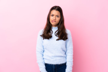 Young Colombian girl over isolated pink background having doubts and with confuse face expression