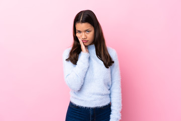 Young Colombian girl over isolated pink background unhappy and frustrated