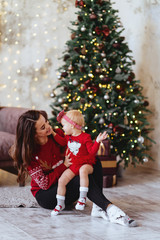 happy family mother and child daughter on Christmas at the Christmas tree with gifts