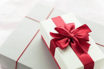 Gift box/ present with red bow on white/pink background. Festive backdrop for holidays: Birthday, Valentines day, Christmas, New Year. Flat lay