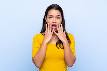 Young Colombian girl over isolated blue background with surprise facial expression