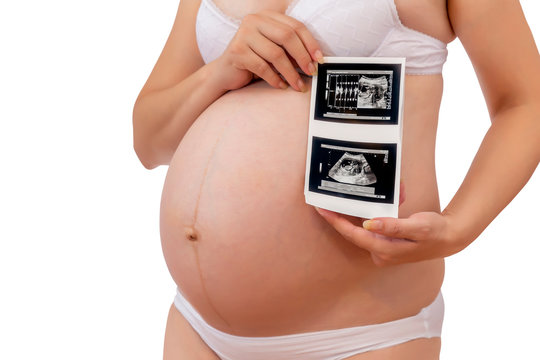 Cropped view of pregnant woman in underwear holding sonogram