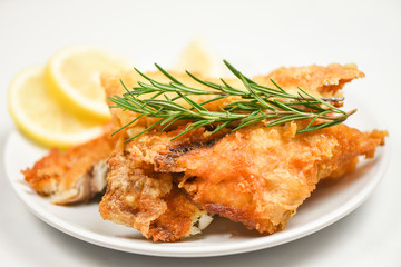 fried fish fillet sliced for steak or salad cooking food with herbs spices rosemary and lemon -...