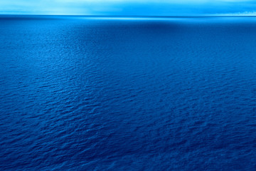 Calm relaxing blue sea in the tropics. Horizon line with blue sky. Trend color.