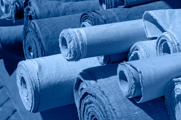 Blue toned rolls of linen canvas textile on market stall
