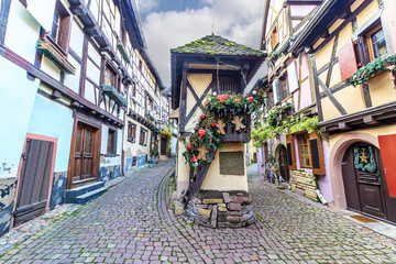 Fototapeta na wymiar Traditional colorful half-timbered houses in Eguisheim Old Town on Alsace Wine Route decorated at Christmas, France