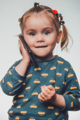 Cute and sincere beautiful girl talking on the phone, portrait of girl 3-4 years.