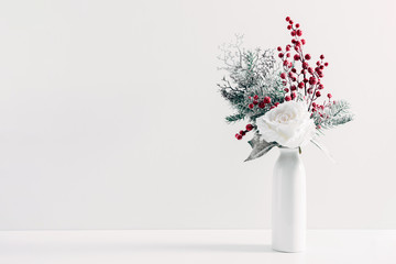 Winter or Christmas composition, decoration, flowers, branches in vase on white background. Christmas home decor, winter concept. Front view, copy space
