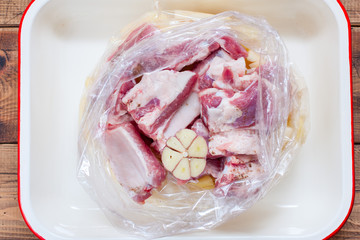 Step-by-step preparation of pork ribs with potatoes in the oven, step 3 - putting all the ingredients in a baking dish, top view, selective focus