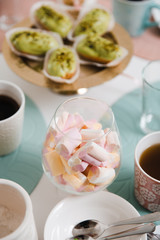 Food served on table in a white hall during a children Birthday party decoration in Eastern European Baltic Riga Latvia - Mild Biege, creme, pink colors - Canape, snacks and light drinks