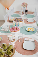 Food served on table in a white hall during a children Birthday party decoration in Eastern European Baltic Riga Latvia - Mild Biege, creme, pink colors - Canape, snacks and light drinks