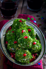 Festive appetizer in the form of balls of salted herring in fresh dill, selective focus