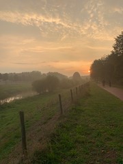 Obraz premium Calm evening by the river, boys cycling