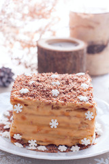 Homemade cake in Christmas decorations on a white plate, selective focus