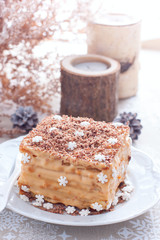 Homemade cake in Christmas decorations on a white plate, selective focus