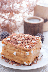 Homemade cake in Christmas decorations on a white plate, selective focus
