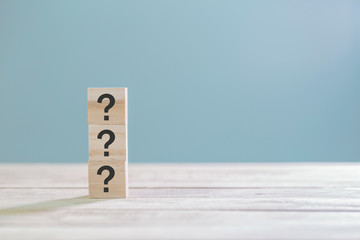 Wooden cube block with sign question mark symbol on wood table with with copy space