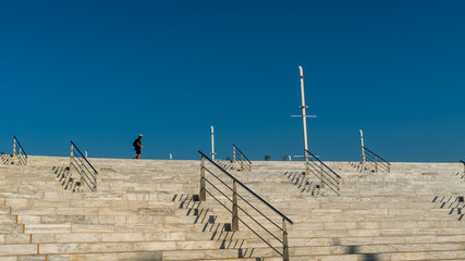 Man walking along top of marble starway at 2004 Olympic Complex