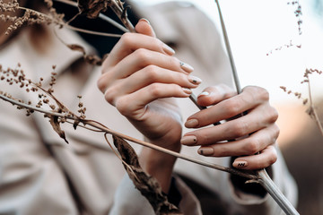 Closeup female hands holds a plant. Beautiful manicure