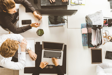 A team of young businessmen working and communicating together in an office. Corporate businessteam and manager in a meeting.