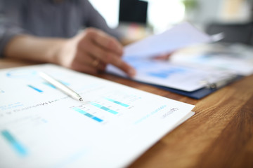 Close up of male employee read paper handout material during office meeting, man analyzing...