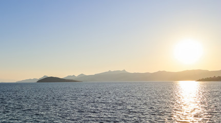 Naklejka na ściany i meble Beautiful sunset on the Mediterranean Sea with islands and mountains