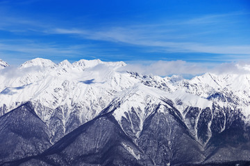 Obraz premium Winter peaks of Caucasus mountain range and blue sky. Rosa Khotor ski resort, Russia. High mountains covered with snow.