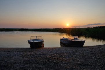 Sunset on lake Seliger. Boats on the shore