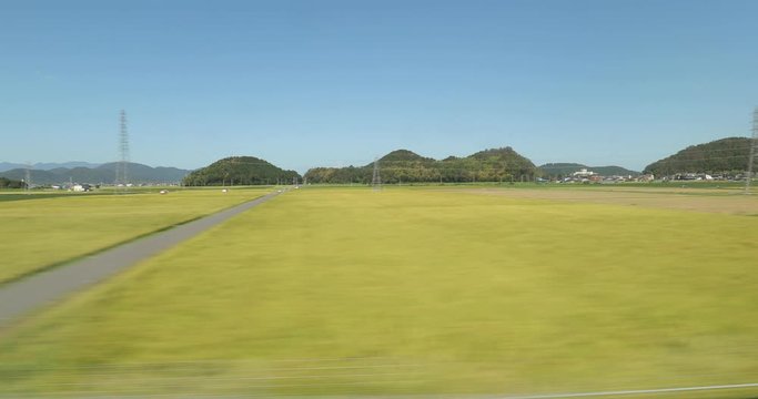 Train journey with high speed train in Japan, country whizzing by