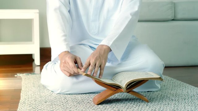 Portrait of an Asian Muslim man reciting surah al-Fatiha passage of the Qur'an, public item of all Muslims in a daily prayer at home in a single act of sujud called a sajdah or prostration