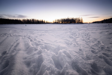 The ice lake and forest has covered with heavy snow and nice blue sky in winter season at Holiday Village Kuukiuru, Finland.
