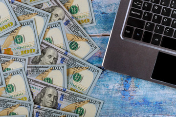 Paper money 100 dollar bills on laptop keyboard financial concept