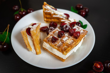 Belgian waffles with whipped cream and fresh ripe cherries