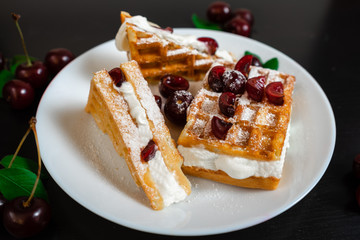Belgian waffles with whipped cream and fresh ripe cherries