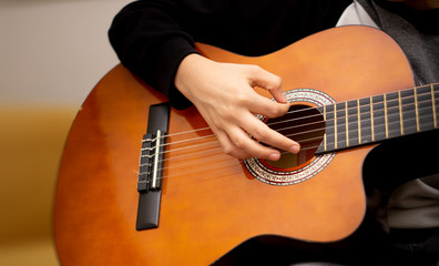 close-up of adult boy playing guitar