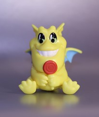 Fototapeta na wymiar toy yellow cheerful dragon with candy
