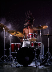 portrait of african man performing music with use of drum set, handsome black naked man