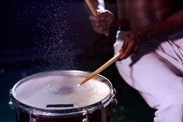 close-up pf man's hands playing on wet drums. african man beating with sticks