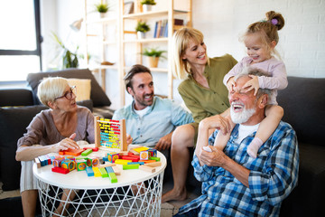 Senior grandparents playing with grandchildren and having fun with family