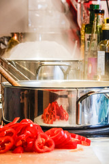 Stockholm, Sweden A steaming pot and a frying pan on the stove with red peppers to be mixed in.