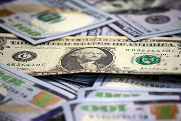 One dollar bill close-up on a pack of one hundred dollars bills