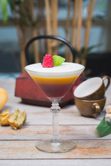 Tiramisu traditional dessert in a glass goblet on a wooden table.